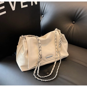 Détail du sac cabas en similicuir crème avec bandoulière en chaîne et texture souple