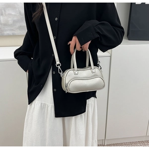 Detailed view of silver lychee pattern texture and hardware on a mini bowling bag