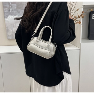 Rear view of model wearing a silver lychee pattern mini bowling bag with strap
