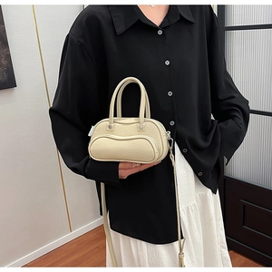 Off-white micro bowling bag with lychee texture pattern shown in a lifestyle indoor setting