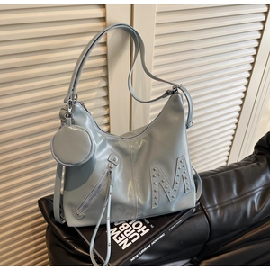 Detail of light blue glossy faux leather tote with rivet M design and small coin purse