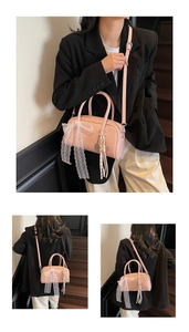 Detailed view of pink Boston bag featuring lace bow pendant and adjustable strap