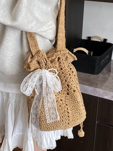 Gehäkelte Eimertasche mit Spitzenschleife und Perlenkette im Boho-Stil