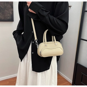 Detail of lychee pattern leather bag with curved zipper pocket and silver hardware