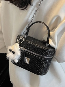 Elegant black woven mini box bag with silver chain strap and plush monster charm decoration