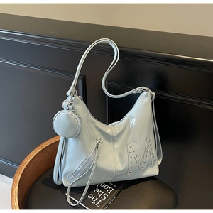 Detail of light blue patent leather tote bag with rivet M logo and mini round coin pouch