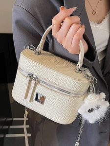 Elegant off-white woven texture handbag with chain strap and fluffy ball charm accessory