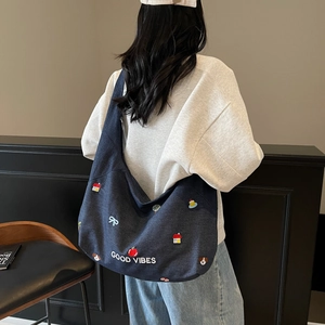 Dettaglio della borsa tote in denim con ricami colorati e scritta Good Vibes