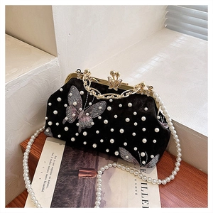 Nahaufnahme der Vintage-Samtabendtasche mit Perlenstickerei und Schmetterlingsdetails