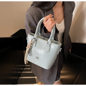 Détail du sac seau bleu menthe en cuir ciré avec finitions argentées et sangle