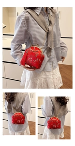 Détail du sac brodé rouge avec fermoir métallique vintage et long gland en soie