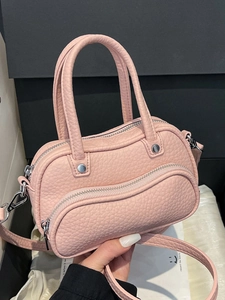 Pink lychee grain leather mini bowling bag with top handles and silver hardware