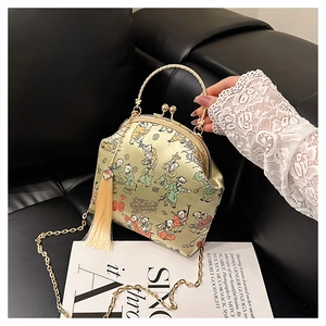 Détail du sac en satin de soie avec broderie et poignée en bambou doré