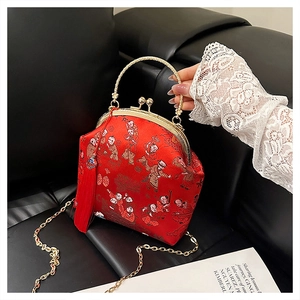 Détail macro du sac en satin rouge avec broderie chinoise et fermoir doré vintage