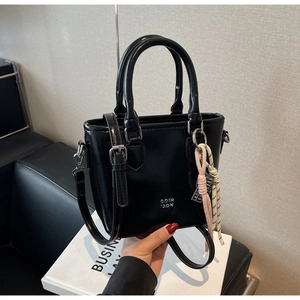 Détail d'un sac cabas en cuir ciré noir brillant avec un ornement tressé élégant