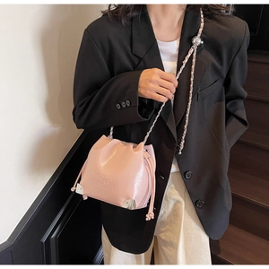 Chic pink glossy bucket bag shown with silver chain strap and metal corner details