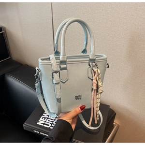 Vue détaillée du sac seau bleu clair en cuir huilé avec poignée et bandoulière