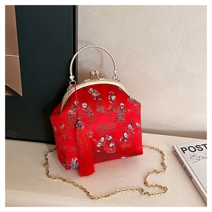 Détail du sac brodé en soie chinoise rouge avec cadre doré et pompon en soie élégant