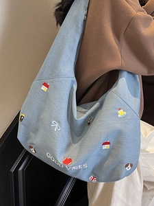 Borsa tote in denim azzurro con ricami colorati e scritta 'GOOD VIBES' su modella