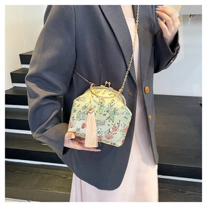 Détail du sac bandoulière vintage avec broderie chinoise traditionnelle et pompon rose