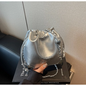 Silver drawstring bucket bag featuring metallic PU leather and chain strap detail
