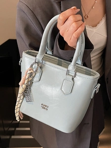 Sac seau minimaliste bleu clair en cuir huilé brillant avec logo en métal argenté