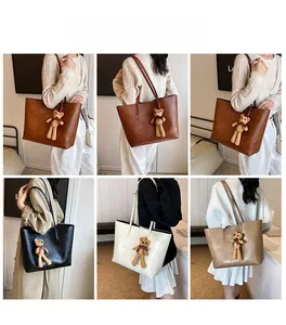 Viste multiple di una borsa tote grande con motivo a pietra e ciondolo a forma di orso