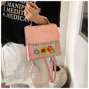 Dettaglio della borsa quadrata rosa con ricamo floreale e finestra trasparente