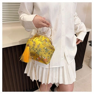 Détail du sac brodé en soie jaune avec motif Baizitu, fermoir en métal et long pompon