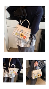 Close-up of beige plaid square bag featuring crochet flower charms and silver swivel lock