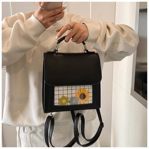 Dettaglio dello zaino in pelle nera con finestra in PVC e graziose decorazioni floreali