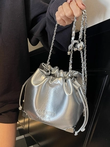 Silver metallic drawstring bucket bag with chain strap and embossed lettering texture