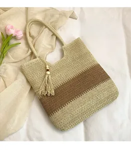 Detailed texture of woven straw tote bag with striped pattern and wooden bead tassel