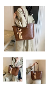 Dettaglio della borsa tote marrone in pelle PU con cuciture patchwork e ciondolo a orsetto