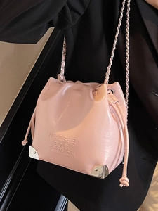 Pink glossy patent leather bucket bag with chain strap and drawstring closure