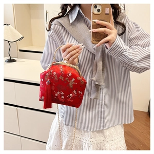 Détail du sac brodé chinois rouge avec motifs traditionnels et long gland en soie rouge