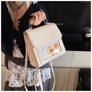 Dettaglio della borsa squadrata in pelle bianco crema con finestra floreale e logo