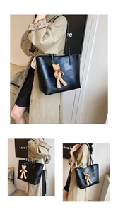 Dettaglio della borsa tote in pelle intrecciata nera con ciondolo a forma di orsetto marrone