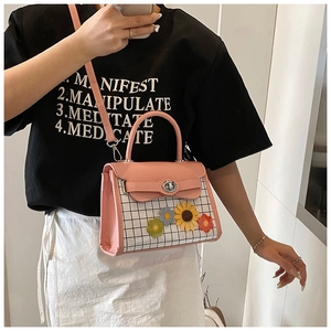 Detail view of the pink and gingham crossbody bag with sunflower appliques and metal clasp