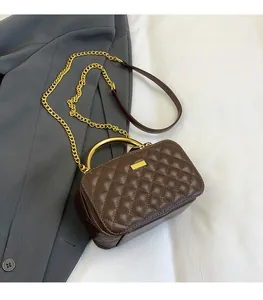 Detail of dark brown quilted faux leather bag with gold chain strap and metal handle