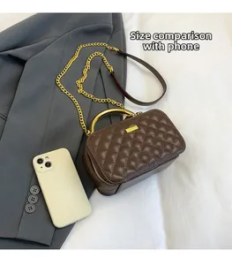 Brown quilted box bag size comparison with a smartphone and gold chain detail