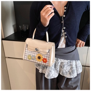 Detail of cream square handbag with black and white plaid and flower embroidery