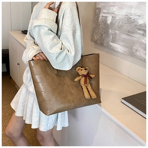 Borsa tote marrone con trama geometrica in pietra e grazioso ciondolo a forma di orso