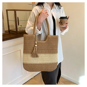 Detail of handwoven color-block tote bag with tassel wooden bead charm on shoulder