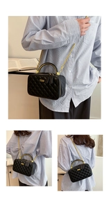 Detail of black quilted PU leather crossbody bag with golden arc handle and chain strap