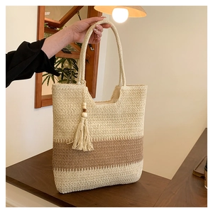 Detailed close-up of woven paper straw texture with brown contrast stripes and tassel