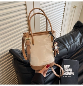 Détail d'un sac seau contrasté beige et marron avec un charmant astronaute et bandoulière