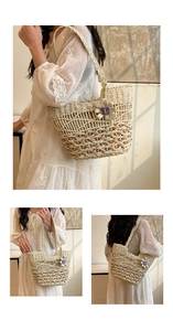 Detailed macro view of handmade woven straw tote bag with purple crochet flower charm