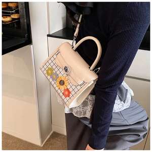 Crossbody view of cream plaid bag with floral embroidery in a modern kitchen setting
