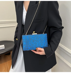 Pochette leopardata blu con catena dorata indossata da modella per uno stile da sera chic